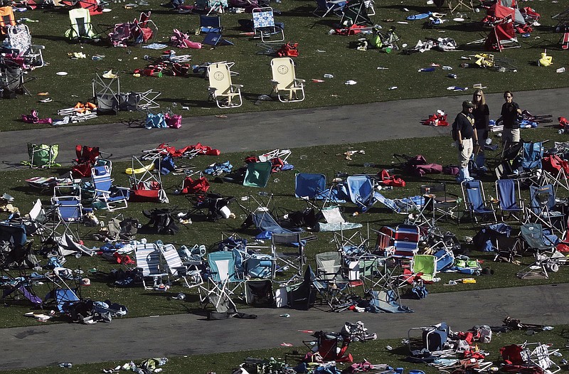 
              FILE - In this Oct. 3, 2017, file photo, investigators work among thousands of personal items at a festival grounds across the street from the Mandalay Bay Resort and Casino in Las Vegas. Friends and relatives of the victims and other concert-goers who survived returned Monday, Oct. 9, 2017, to reclaim baby strollers, shoes, phones, backpacks and purses left behind in the panic as they fled, at a Family Assistance Center at the Las Vegas Convention Center. (AP Photo/Marcio Jose Sanchez, File)
            