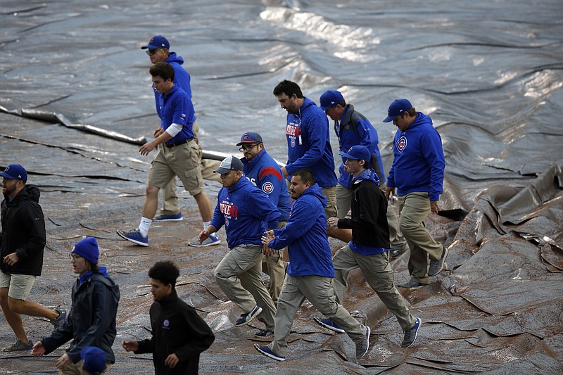 
              Ground crew cover the infield before Game 4 of baseball's National League Division Series between the Chicago Cubs and the Washington Nationals, Tuesday, Oct. 10, 2017, in Chicago. (AP Photo/Charles Rex Arbogast)
            