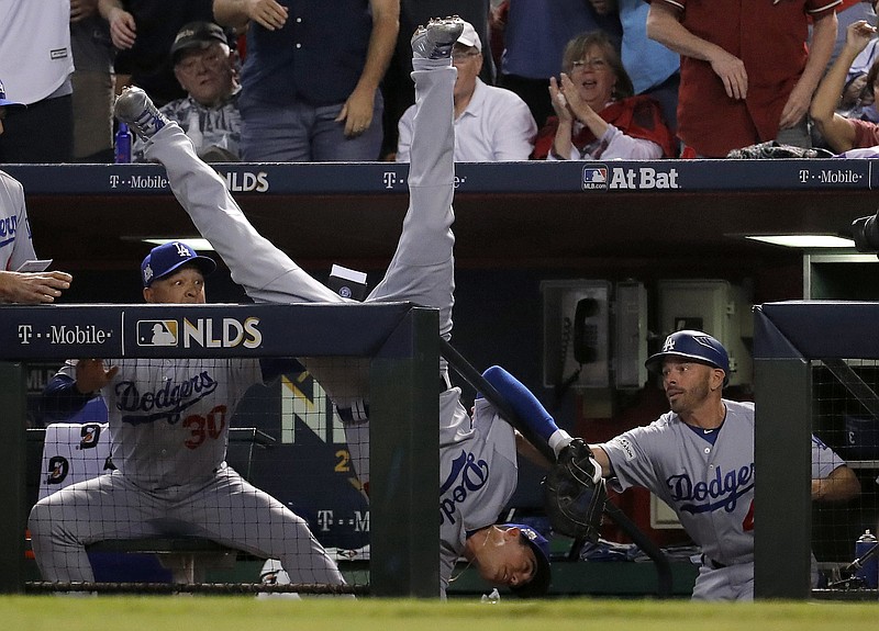 Los Angeles Dodgers' Cody Bellinger falls in the dugout after catching a foul ball by Arizona Diamondbacks' Jeff Mathis during the fifth inning of game 3 of baseball's National League Division Series, Monday, Oct. 9, 2017, in Phoenix. (AP Photo/Rick Scuteri)