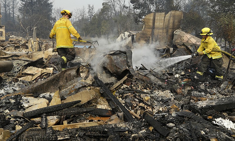
              Firefighters douse hot spots in the Coffey Park area of Santa Rosa, Calif., on Tuesday, Oct. 10, 2017. An onslaught of wildfires across a wide swath of Northern California broke out almost simultaneously then grew exponentially, swallowing up properties from wineries to trailer parks and tearing through both tiny rural towns and urban subdivisions. (AP Photo/Ben Margot)
            