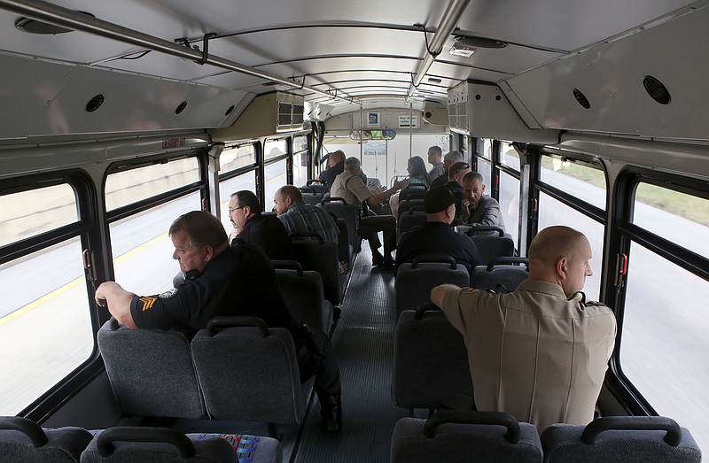 Law enforcement offices and others ride aboard the Tennessee Highway Patrol's distracted driving bus on Wednesday, Oct. 11, in Chattanooga, Tenn. The bus, marked like THP cars, patrolled the highways around Chattanooga. Law enforcement officials aboard the bus monitored and reported distracted drivers and other offensives, such as not wearing seatbelts, to other officers on the road.