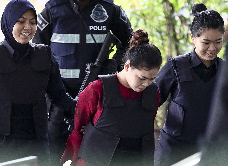 
              Indonesian Siti Aisyah, center, is escorted by police officers as she arrives for a court hearing at Shah Alam court house in Shah Alam, outside Kuala Lumpur, Malaysia, Thursday, Oct. 12, 2017. Security camera videos showed Wednesday Kim Jong Nam, the estranged half brother of North Korea's leader, being attacked at a Malaysian airport and the two suspects, including Aisyah, hurrying away afterward have been presented at their murder trial. (AP Photo/Sadiq Asyraf)
            