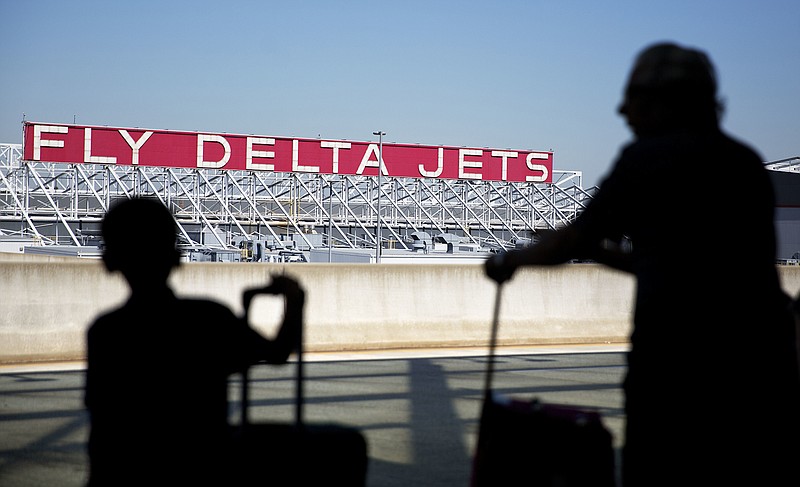 
              FILE - In this Thursday, Oct. 13, 2016, file photo, a Delta Air Lines sign overlooks the unloading area at Hartsfield-Jackson Atlanta International Airport, in Atlanta. Delta Air Lines, Inc. reports earnings, Wednesday, Oct. 11, 2017. (AP Photo/David Goldman, File)
            