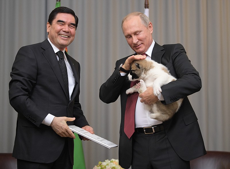 
              Turkmenistan's President Gurbanguly Berdymukhamedov, right, smiles as he presents a puppy to Russian President Vladimir Putin during their meeting in the Bocharov Ruchei residence in the Black Sea resort of Sochi, Russia, Wednesday, Oct. 11, 2017. The presidents met on the sidelines of a summit of leaders of ex-Soviet nations in Sochi. (Alexei Druzhinin/Sputnik, Kremlin Pool Photo via AP)
            