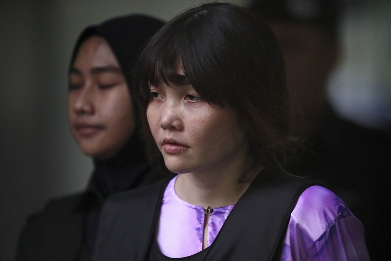 Vietnamese Doan Thi Huong, escorted by police as she leaves after the court hearing at Shah Alam court house in Shah Alam, outside Kuala Lumpur, Malaysia, Tuesday, Oct. 10, 2017. A chemist says the North Korean leader's brother had about 1.4 times the lethal dosage of VX nerve agent on his face after being attacked at a Malaysian airport. The chemist, testifying at the trial of two women accused of killing Kim Jong Nam, also said the fatal poison could not have been a two-part concoction but acknowledged VX or part of it may have been smuggled into the country.(AP Photo/Sadiq Asyraf)
