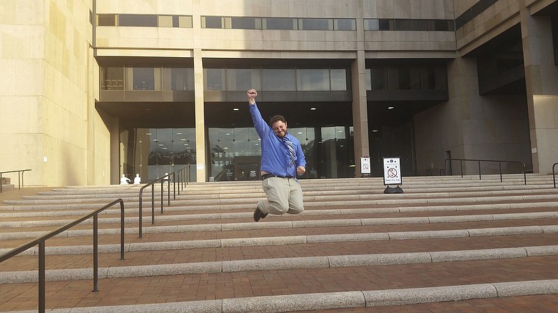 In this Aug. 11, 2016 photo provided by the The Chandra Law Firm, Anthony Novak jumps outside a Cuyahoga County courthouse after being acquitted for creating a Facebook page parodying a suburban Cleveland police department in Cleveland, Ohio. Novak filed a lawsuit against the City of Parma and three officers, saying they violated his right to free speech by arresting and jailing him for creating the Facebook page in March 2016. (Michelle Novak/The Chandra Law Firm via AP)