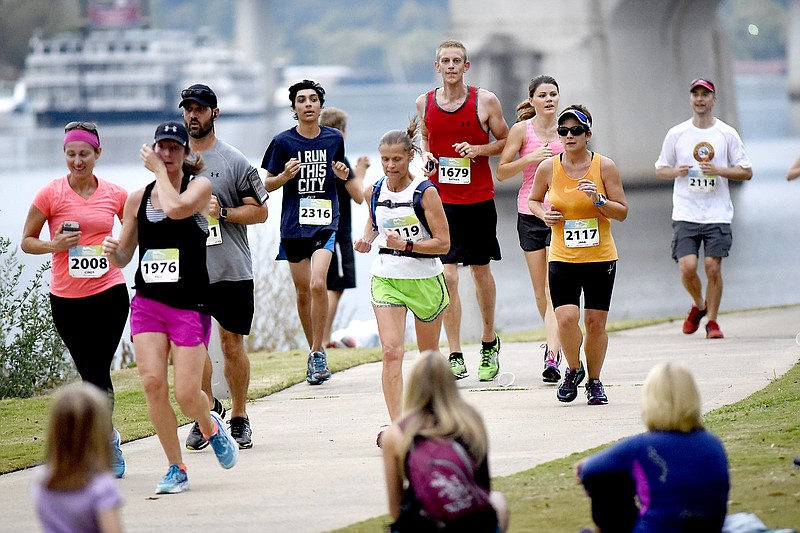 Runners pass Coolidge Park with the Tennessee River in the background.  The 7 Bridges Marathon and 4 Bridges Half Marathon, along with a 5K run were held simultaneously Sunday October 16, 2016 along the Tennessee River in Chattanooga.