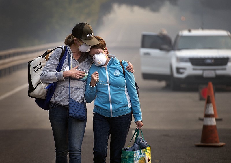 
              Colby Clark of San Francisco, left, comforts her mother, Bonnie Trexler, after being escorted by law enforcement to her home in Silverado Highland to retrieve medicine and some personal items on Wednesday, Oct., 11, 2017 in Napa, Calif. Trexler was one of the lucky few who found that her home was spared from the devastating fire which burned homes around her Monday. (Randy Pench /The Sacramento Bee via AP)
            