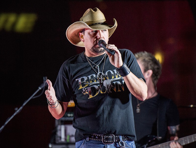 
              FILE - In this June 7, 2017 file photo Jason Aldean performs during a surprise pop up concert at the Music City Center in Nashville, Tenn. Aldean is set to make an emotional return to the stage, Thursday, Oct. 12 in Tulsa, Oklahoma, after cancelling tour dates following the mass shooting in Las Vegas. The singer was onstage Oct. 1 when a gunman sprayed bullets into the crowd at the outdoor Route 91 Harvest festival, killing dozens of people and leaving hundreds injured.  (Photo by Amy Harris/Invision/AP, File)
            