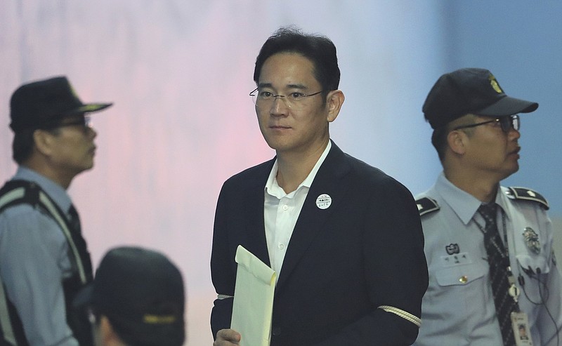 
              Lee Jae-yong, center, vice chairman of Samsung Electronics, arrives at the Seoul Central District Court for a hearing in Seoul, South Korea, Thursday, Oct. 12, 2017. Prosecutors are citing a past ruling on a North Korean spy case as one reason why Samsung's billionaire heir deserves a lengthy prison term for his conviction on bribery charges. The prosecutors and Samsung lawyers sparred Thursday during a first hearing by the appeals court on the effort by Lee to have his five-year prison sentence overturned. (AP Photo/Lee Jin-man)
            