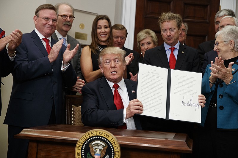 President Donald Trump shows an executive order on health care purchasing that he signed in the Roosevelt Room of the White House on Thursday.