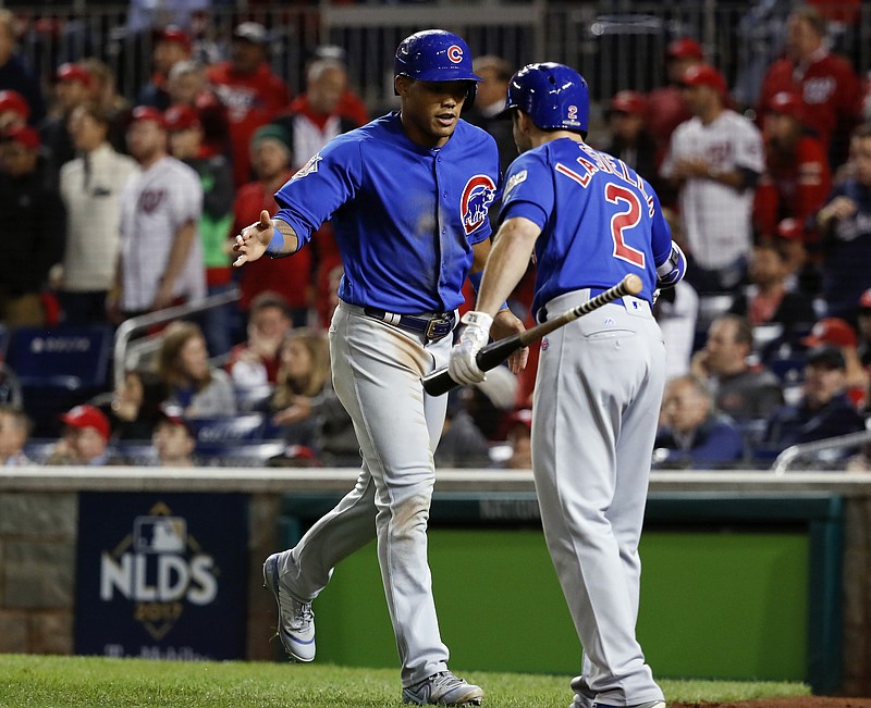 Chicago Cubs' Addison Russell is congratulated by Cub's pinch-hitter Tommy La Stella (2) after he scored during the fifth inning in Game 5 of baseball's National League Division Series against the Washington Nationals, at Nationals Park, Thursday, Oct. 12, 2017 in Washington. (AP Photo/Pablo Martinez Monsivais)