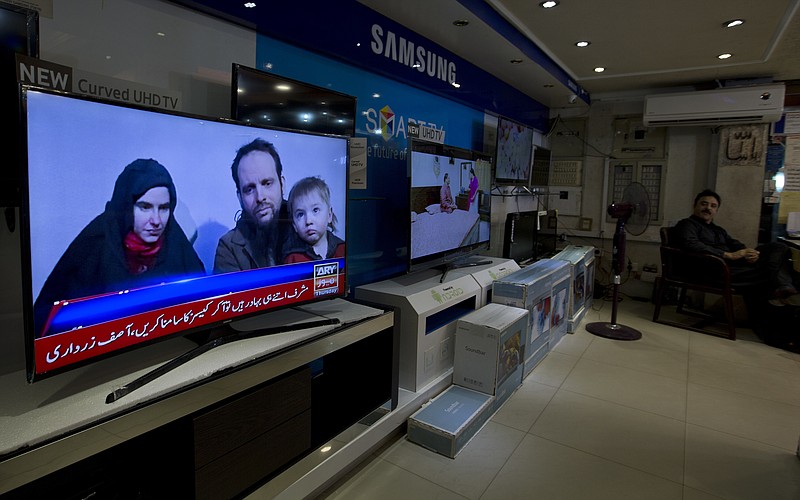 
              A Pakistani channel broadcasts a report about western couple, seen at a local electronic shop in Islamabad, Pakistan, Thursday, Oct. 12, 2017. An American woman, her Canadian husband and their three young children have been released after years of being held captive by a network with ties to the Taliban, U.S. and Pakistani officials said Thursday. (AP Photo/B.K. Bangash)
            