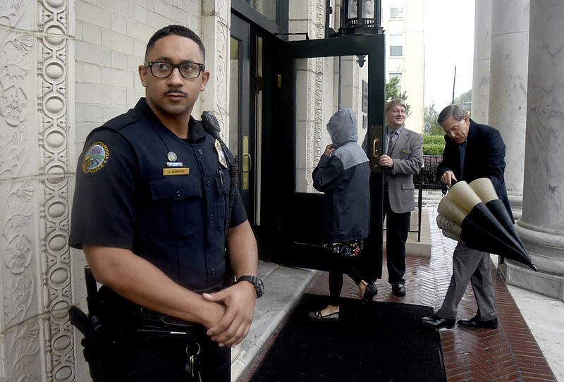 Off-duty Chattanooga Police Officer Jeremy Winbush takes up his station outside the main entrance to First Presbyterian Church.  In the background Deacon Walt Goldston welcomes church members.  In the wake of shootings at places of worship churches such as First Presbyterian has have deployed security personal to protect their members.  First Presbyterian's security details were photographed on October 8, 2017.