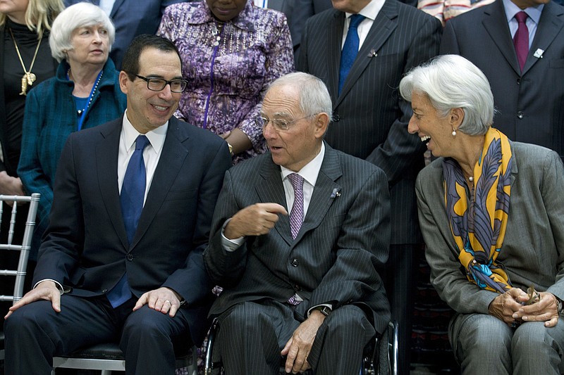 
              From left, U.S. Treasury Secretary Steven Mnuchin, Germany Finance Minister Wolfgang Schäuble, and International Monetary Fund (IMF) Managing Director Christine Lagarde speak during the Monetary Fund (IMF) Governors group photo during World Bank/IMF annual meetings in Washington, Saturday, Oct. 14, 2017. At background left is U.S Federal Reserve Chair Janet Yellen. (AP Photo/Jose Luis Magana)
            