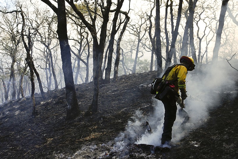 
              A firefighter mops up the area scorched by a wildfire Saturday, Oct. 14, 2017, in Santa Rosa, Calif. Fire crews made progress this week in their efforts to contain the massive wildfires in California wine country, but officials say strong winds are putting their work to the test. (AP Photo/Jae C. Hong)
            