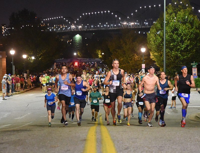 Shortly after 7 a.m., Nathan Pierce, second from right, 31, of Huntsville, begins his first place run to the finish line in the Seven Bridges Marathon Sunday morning. A miscalculation left the race 0.63-miles too long, according to three race officials. The Four Bridges Half Marathon was 0.63-miles too short.