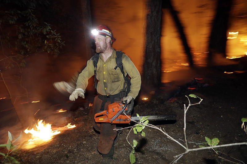 
              A firefighter runs along a containment line while battling a wildfire Saturday, Oct. 14, 2017, in Santa Rosa, Calif. (AP Photo/Marcio Jose Sanchez)
            