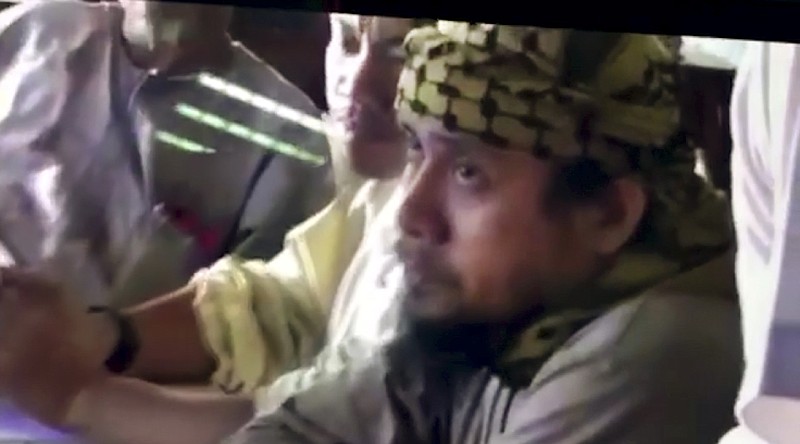 
              FILE - This file image taken from undated video shown to The Associated Press by the Philippine military shows the purported leader of the Islamic State group Southeast Asia branch, Isnilon Hapilon, right, at a meeting of militants at an undisclosed location. Philippine security officials told The Associated Press that Isnilon Hapilon, who is listed among the FBI's most-wanted terror suspects, and Omarkhayam Maute were killed in a gunbattle and their bodies were found Monday, Oct. 16, 2017 in Marawi. (Philippines Military via AP, File)
            