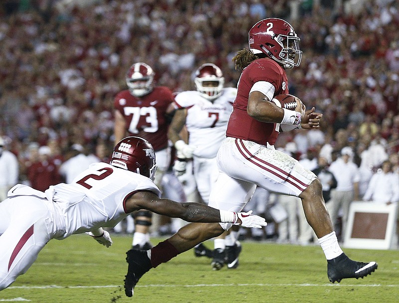 Alabama quarterback Jalen Hurts runs in for a touchdown as Arkansas defensive back Kamren Curl reaches for him during the first half an NCAA college football game Saturday, Oct. 14, 2017, in Tuscaloosa, Ala. (AP Photo/Brynn Anderson)