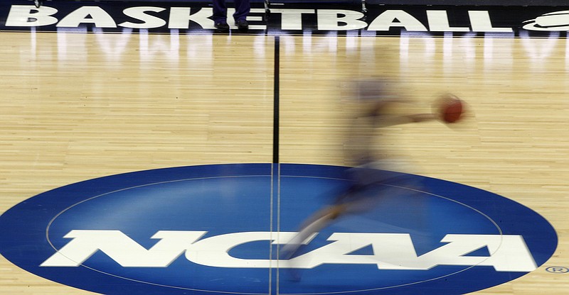 
              FILE - In this March 14, 2012, file photo, a player runs across the NCAA logo during practice in Pittsburgh before an NCAA tournament college basketball game. The spate of arrests, the details of under-the-table bribes to teenagers and the expected downfall of one of the sport’s best-known coaches has triggered uncomfortable soul searching among universities that run the nation’s most prominent college basketball programs.
 At stake is the future of a business that, over the span of 22 years ending in 2032, will produce $19.6 billion in TV money for the NCAA Tournament, known to the public, simply, as March Madness. (AP Photo/Keith Srakocic, File)
            