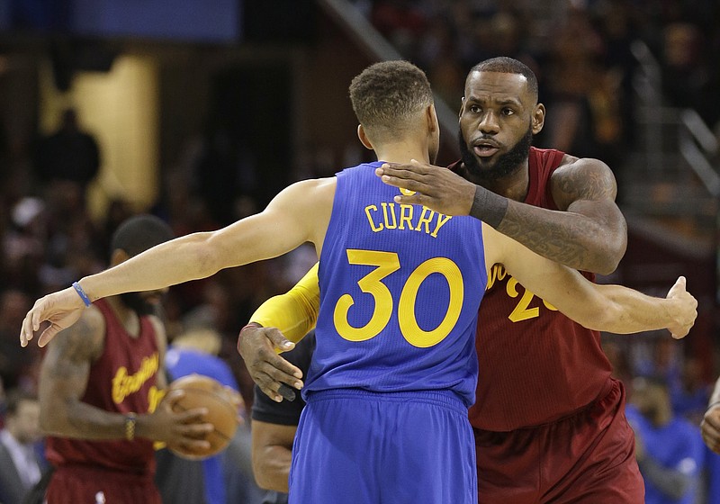 
              FILE - This Sunday, Dec. 25, 2016, file photo shows Cleveland Cavaliers' LeBron James, right, hugging Golden State Warriors' Stephen Curry before an NBA basketball game, in Cleveland. The Warriors and Cavaliers are being penciled in to meet in the NBA Finals once again. They're going to drive most of the conversation this season, a fact that is not lost on the league or its TV partners. When the season tips off Tuesday, Cleveland will take the center stage first, followed by the Warriors.(AP Photo/Tony Dejak, File)
            