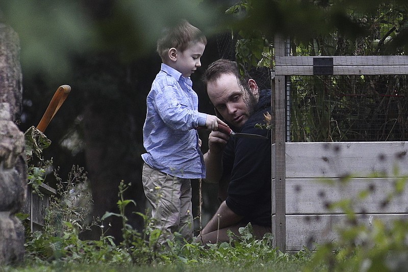 
              Joshua Boyle and son Jonah play in the garden at his parents house in Smiths Falls, Ont., on Saturday, Oct. 14, 2017. A couple held hostage for five years by a Taliban-linked network and forced to raise three children while in captivity were initially targeted for ransom because of the impending birth of their first child, the Canadian man at the heart of the case speculated Saturday. Boyle said he and his wife Caitlan Coleman heard at least half a dozen reasons why they had been snatched from a village in Afghanistan and held against their will by the Haqqani network over the years they were imprisoned. (Lars Hagberg/The Canadian Press via AP)
            