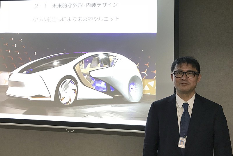 
              Toyota Motor Corp. manager Makoto Okabe stands in front of a image of the concept car "TOYOTA Concept-i" series Monday Oct. 16, 2017 in Tokyo. The use of artificial intelligence means cars may get to know drivers as human beings by analyzing their facial expressions, driving habits and social media use. (AP Photo/Yuri Kageyama)
            