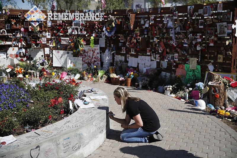 
              Jenni Tillett writes a message at the Las Vegas Community Healing Garden, Monday, Oct. 16, 2017, in Las Vegas. The garden was built as a memorial for the victims of the recent mass shooting in Las Vegas. (AP Photo/John Locher)
            