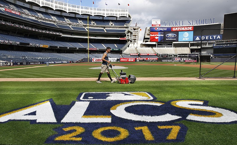 
              A groundskeeper mows the grass around a recently painted field logo before an American League Championship Series baseball workout day at Yankee Stadium in New York, Sunday, Oct. 15, 2017. (AP Photo/Kathy Willens)
            