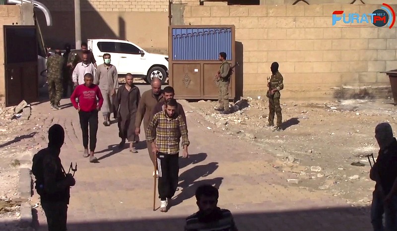 
              This frame grab from video released Sunday, Oct. 15, 2017 and provided by Furat FM, a Syrian Kurdish activist-run media group, shows Syrian Islamic State group fighters who surrendered entering a base of the U.S.-backed Syrian Democratic Forces (SDF), in Raqqa, Syria. A spokesman for the SDF in Syria says it will be in control of the northern city of Raqqa "within a few days" after attacking the last pocket held by the Islamic State group. SDF fighters launched an operation to retake the last IS-held pocket of Raqqa after some 275 militants and their family members surrendered. (Furat FM, via AP)
            