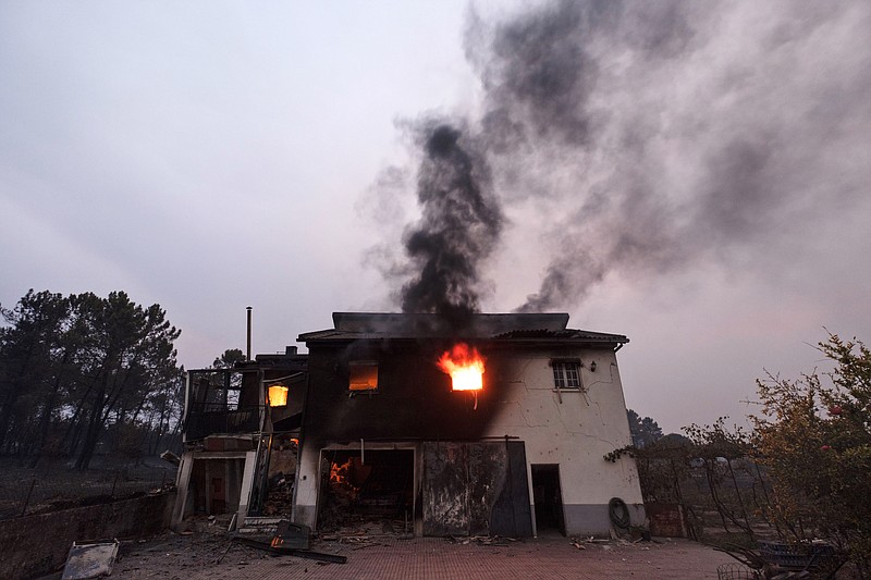 
              A house burns in the village of Pinheiro dos Abracos near Oliveira do Hospital, northern Portugal, Monday, Oct. 16 2017. Late season wildfires that broke out over the weekend in Portugal have killed at least 35 people, including a 1-month-old infant, authorities said Monday, making 2017 by far the deadliest year on record for forest blazes in the country. (AP Photo/Sergio Azenha)
            
