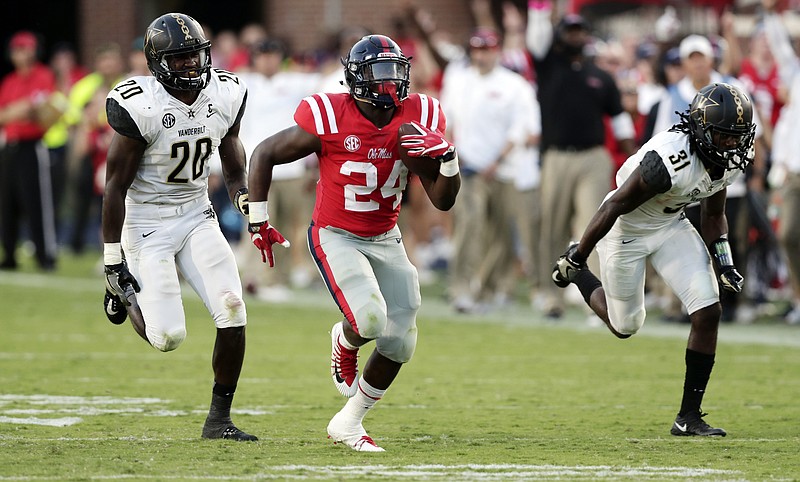 Mississippi running back Eric Swinney (24) pulls away from Vanderbilt linebacker Oren Burks (20) and cornerback Tre Herndon (31) for a 55-yard touchdown run in the second half of an NCAA college football game in Oxford, Miss., Saturday, Oct. 14, 2017. Mississippi won 57-35. (AP Photo/Rogelio V. Solis)