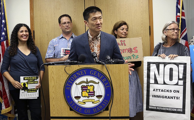 FILE - In this June 30, 2017 file photo, Hawaii Attorney General Douglas Chin speaks at a news conference in Honolulu about President Donald Donald Trump's travel ban. On Tuesday, Oct. 17, 2017 a federal judge in Hawaii blocked the Trump administration from enforcing its latest travel ban, just hours before it was set to take effect. U.S. District Judge Derrick Watson granted Hawaii's request to temporarily block the policy from taking effect Wednesday. (AP Photo/Caleb Jones, File)