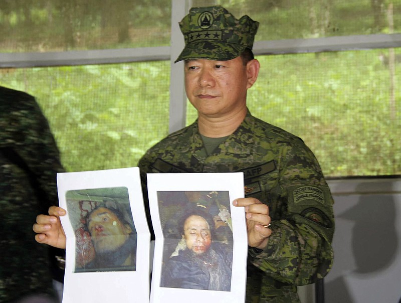 
              In this photo released by the 4th Civil Relations Group, Civil Relations Service Armed Forces of the Philippines, Philippine military chief Gen. Eduardo Ano holds pictures of dead militant leaders during a press conference at a military camp in Marawi, southern Philippines on Monday, Oct. 16, 2017. The last two surviving leaders of a deadly siege in the southern Philippines, including a top Asian terror suspect, were killed Monday in a push by thousands of troops to retake the last pocket of Marawi city still held by pro-Islamic State militants, top security officials said. Officials said that Isnilon Hapilon, who is listed among the FBI's most-wanted terror suspects, and Omarkhayam Maute were killed in a gunbattle and their bodies were found Monday in Marawi. (4th Civil Relations Group, Civil Relations Service Armed Forces of the Philippines via AP)
            