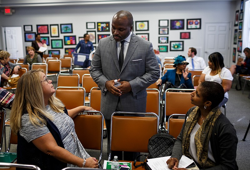 Hamilton County Schools superintendent Bryan Johnson, center, speaks with Mary Edwards, right, and Lee Ann Hammer before giving a "State of Our Schools" address to the Hamilton County Council of PTAs in the Hamilton County Department of Education board room on Wednesday, Oct. 18, 2017, in Chattanooga, Tenn.