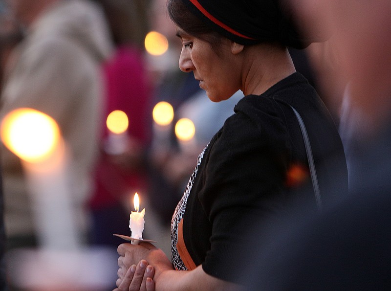 Zain Arif stands for a moment of silence with others Wednesday, Oct. 18, 2017, during a We All Belong vigil at Coolidge Park in Chattanooga, Tenn. The event was part of a national day of action to put out the message that no Muslim ban is wanted and to welcome refugees. 