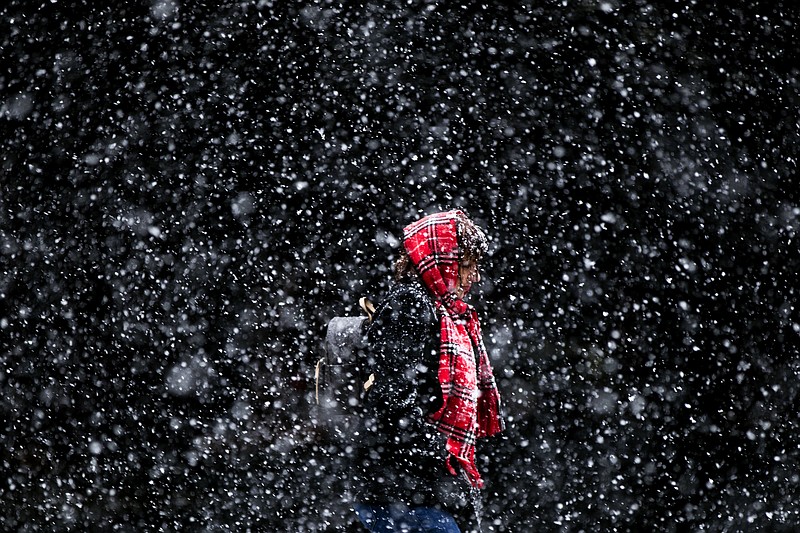 FILE - In this March 10, 2017 file photo, a woman walks through a winter snow storm in Philadelphia. In a report released Thursday, Oct. 19, U.S. forecasters say chances are good that much of the nation will have a warmer than normal winter. But it likely won't be as toasty as the previous two winters. (AP Photo/Matt Rourke, File)