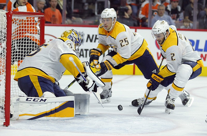 Nashville Predators' Pekka Rinne, left, defends as Anthony Bitetto, right, looks to clear the puck from the crease during the second period of an NHL hockey game against the Philadelphia Flyers, Thursday, Oct. 19, 2017, in Philadelphia. (AP Photo/Tom Mihalek)