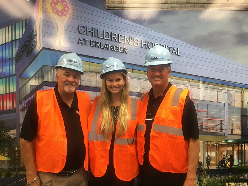 Jim, Alexis, and Steve Frost are pictured in front of a rendering of the new Children's Hospital at Erlanger.