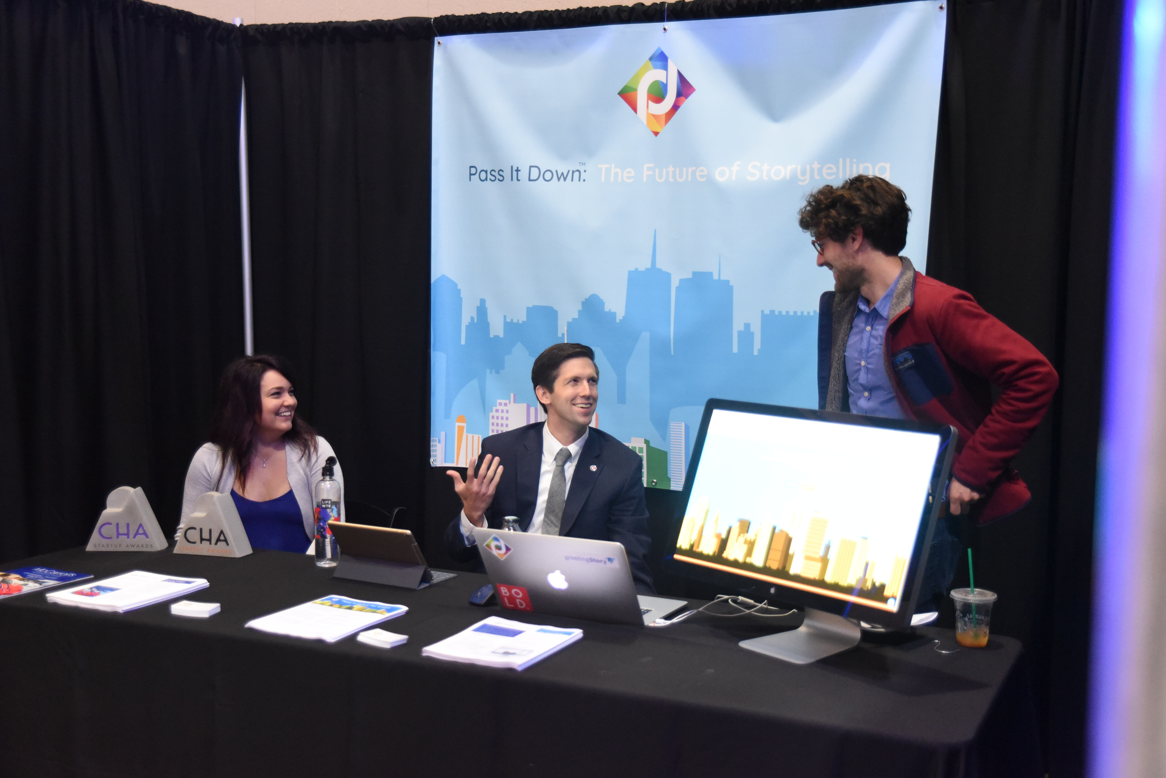 Chris Cummings, center, founder and CEO of Pass It Down, talks with his team, Victoria Bruck, left, and Josh Waggoner, Friday before receiving top company at the Spirit of Innovation Awards at the Chattanooga Convention Center.