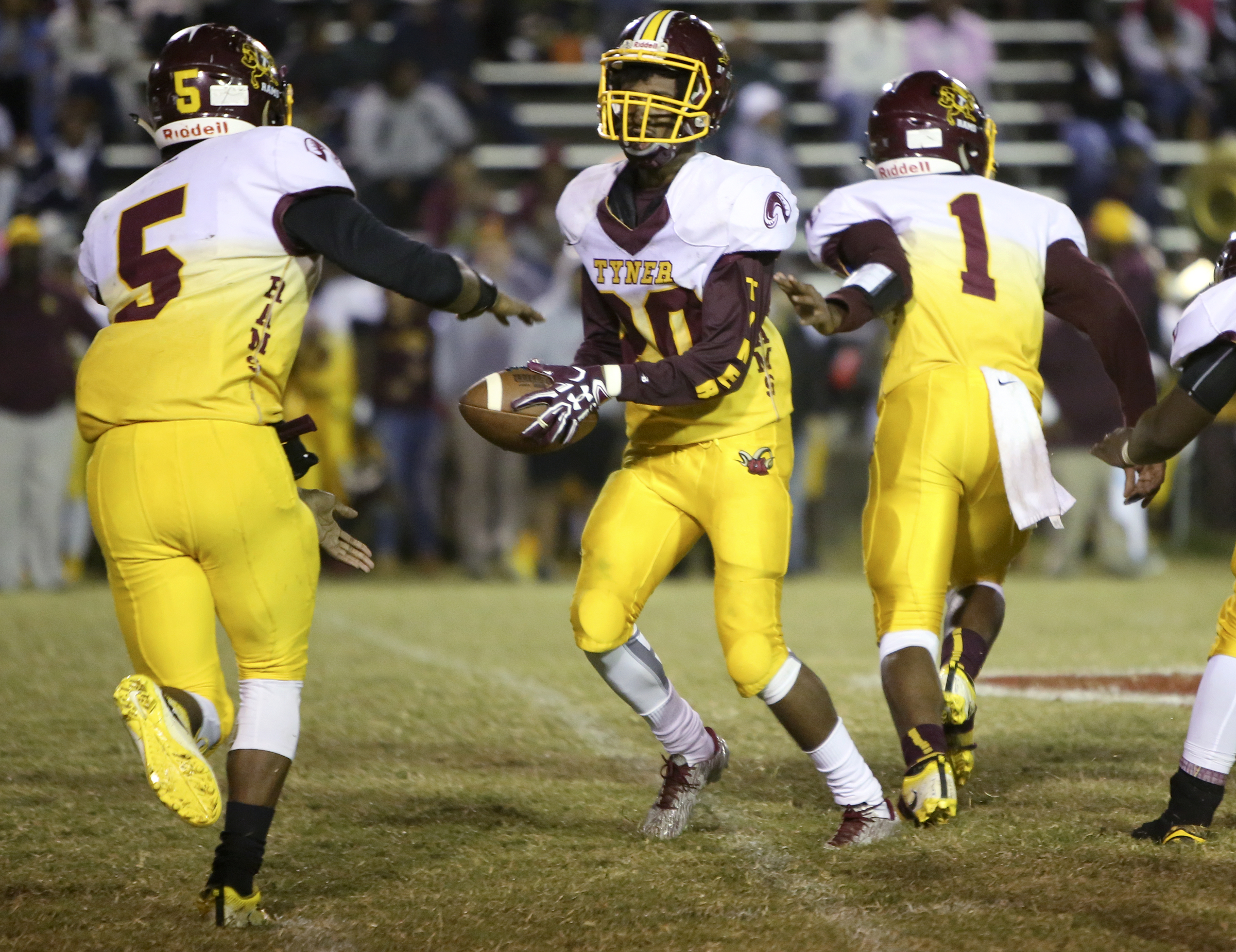After taking a handoff from Martavius Ryals (1), Tyner's Jeremy Elston (20) goes to hand the ball off to Keյn Webb (5) against Brainerd at Brainerd High School on Friday, Oct. 20, in Chattanooga, Tenn.