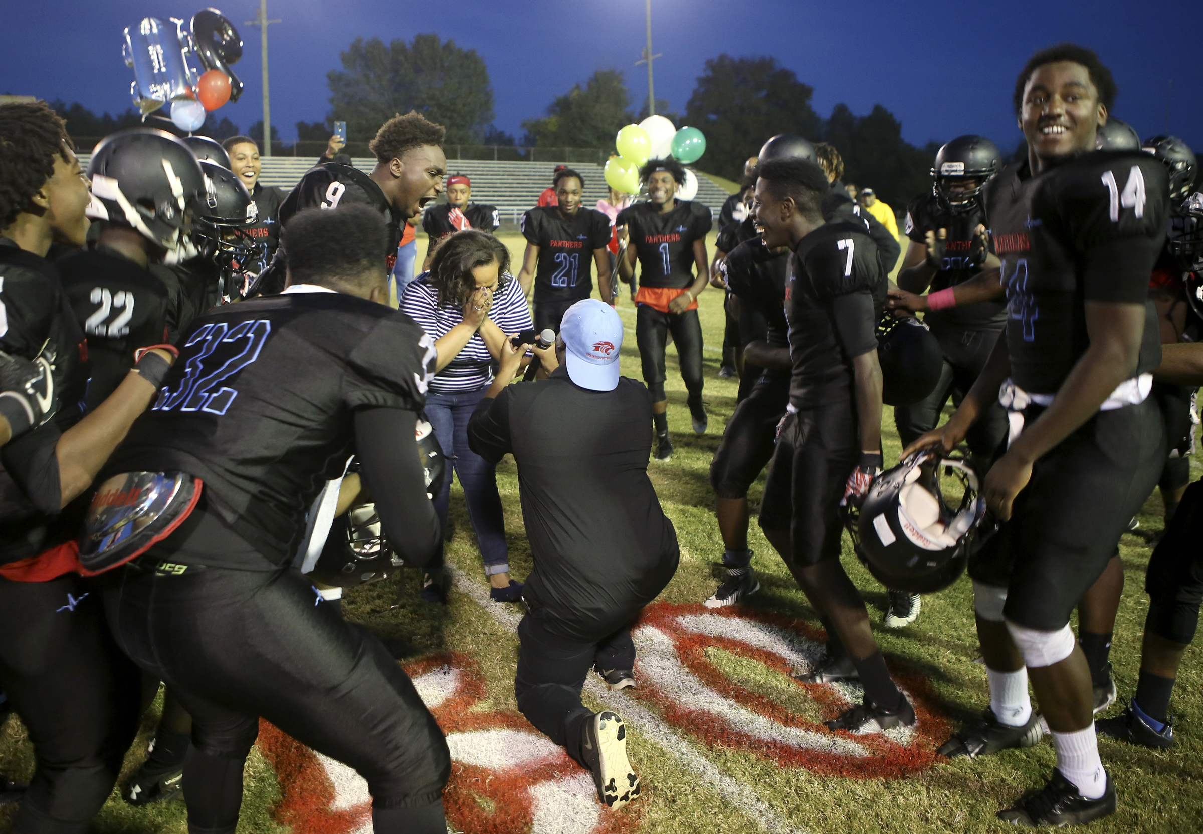 Brainerd assistant coach Dexter Jones proposes to his now-fiance Trinity Few before the Panthers' game against the Tyner Rams at Brainerd High School on Friday, Oct. 20, in Chattanooga, Tenn.