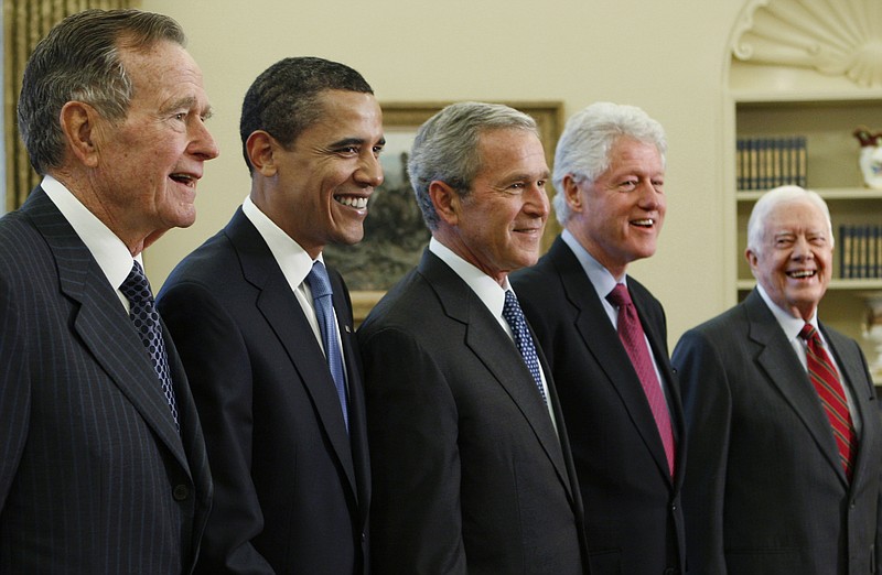 FILE - In this Jan. 7, 2009 file photo, Then-President George W. Bush, center, poses with President-elect Barack Obama, and former presidents, from left, George H.W. Bush, left, Bill Clinton and Jimmy Carter, right, in the Oval Office of the White House in Washington. All five living former U.S. presidents will be attending a concert Saturday night, Oct. 21, 2017, in a Texas college town, raising money for relief efforts from Hurricane Harvey, Irma and Maria's devastation in Texas, Florida, Puerto Rico and the U.S. Virgin Islands. (AP Photo/J. Scott Applewhite)