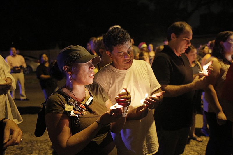 
              During a candlelight vigil Jacqueline Melendez, left, and her husband Jose Melendez mourn the death of three victims who were killed in the recent shootings in the Seminole Heights neighborhood in Tampa on Sunday, October 22, 2017. The deaths, which took place in the same neighborhood over the past 10 days, prompted Tampa police to warn residents in the Seminole Heights neighborhood not to walk alone at night.(Octavio Jones/The Tampa Bay Times via AP)
            