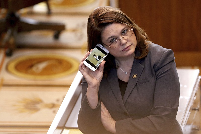 FILE - In this March 3, 2016, file photo, Oregon state Sen. Sara Gelser, D-Corvallis, listens to a live stream as members of the House of Representatives finish business before adjourning the 2016 legislative session at the Oregon State Capitol in Salem, Ore. Democratic Sen. Gelser, who accused Republican Sen. Jeff Kruse of inappropriate touching, said Monday, Oct. 23, 2017, she heard accounts from other women in the Oregon State Capitol of such behavior by men. (Anna Reed/Statesman-Journal via AP, File)