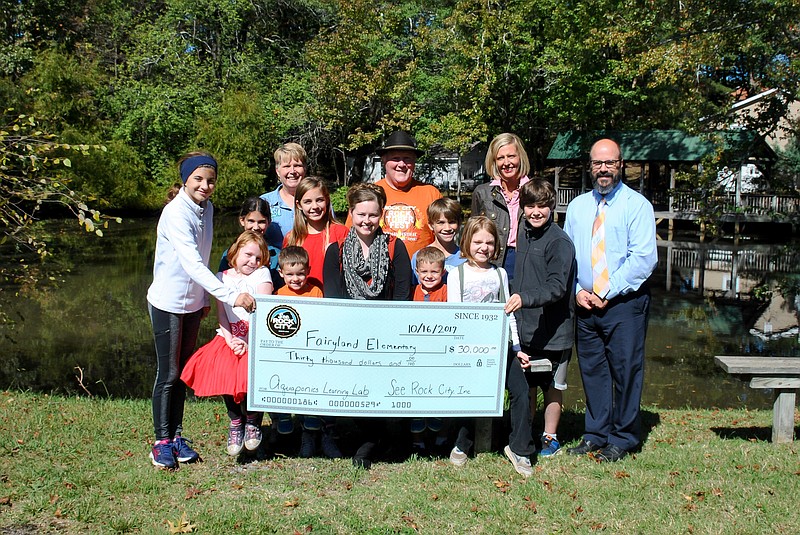 At the check presentation are front, from left, Torunn Snider, Emmett Mills, Mary Mills, See Rock City partner and parent, Isaiah Mills and McKenna Snider. On the middle row are Charlotte Myers, Ellison Ball, Carrie Rogers, Canon Brock and Johnny Sutter. In back are See Rock City President Susan Harris, See Rock City Chief Executive Officer Bill Chapin, Fairyland Assistant Principal Emily Haney and Principal Jeremy Roerdink.