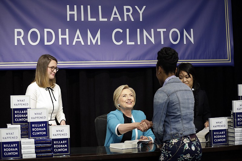 Hillary Rodham Clinton, center, greets people who waited in line for a signed copy of her book "What Happened," for which she received an advance of $21 million.