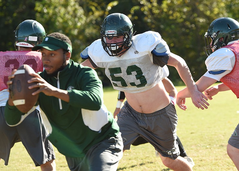 Silverdale lineman McCaulley McGuire (53) breaks though the line and chases assistant Edgar Montgomery during practice on Wednesday, Oct. 25, 2017.