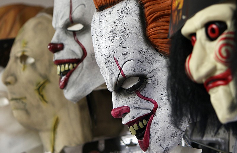 Masks hang above costumes Thursday, Oct. 26, 2017, at Beauty and the Beast Costumes in Red Bank, Tenn. Clown costumes and superhero costumes have been this year's top pick for those searching for the perfect Halloween costume. 